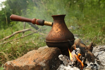 close-up of a copper pot in which coffee is cooked  at the bonfire