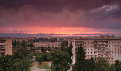 evening cityscape before the rain, the city Sumy, Ukraine, the sky with dark clouds and red light
