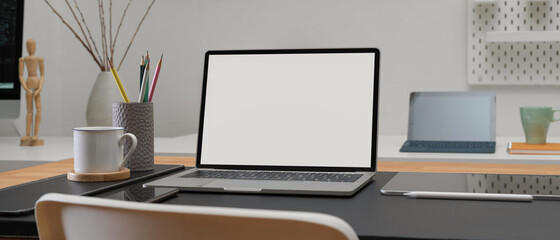 Designer office desk with mock-up laptop, digital tablet, smartphone, stationery and decoration in office room