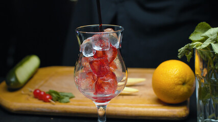 Preparing cherry sling cocktail