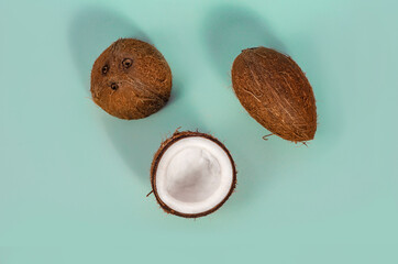 Exotic nut. Whole and half coconut on a blue background with copy space for text. Flat lay
