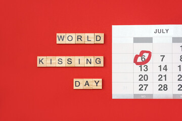 Words World Kissing Day. Wooden tiles with letters and calendar on red background. Layout, top view