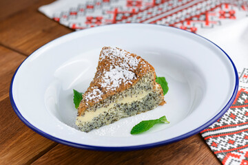Fresh homemade poppy seed cake with vanilla cream and powdered sugar.