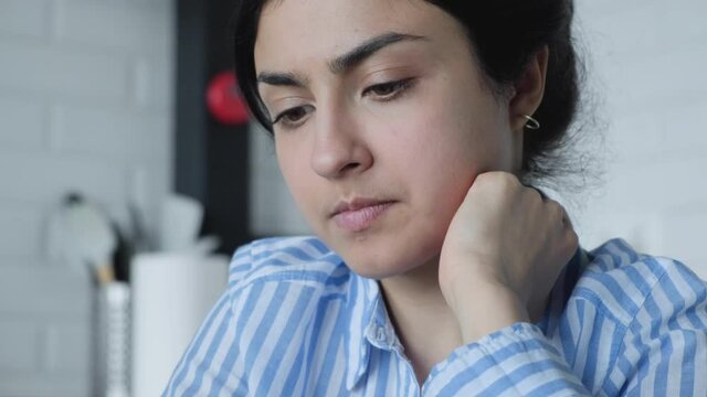 Thoughtful concerned indian woman working on computer thinking solving problem