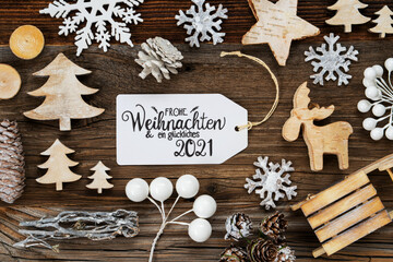 Obraz na płótnie Canvas One White Label With German Text Frohe Weihnachten Und Ein Glueckliches 2021 Means Merry Christmas And A Happy 2021. Frame Of Christmas Decoration Like Tree, Sled, Star And Fir Cone.