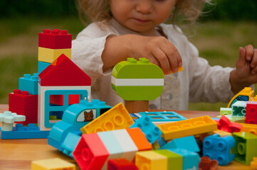 Colorful plastic toys. Construction toys. Early development concept. Baby playing with colorful plastic toys. Baby playing in playground. Preschool concept 