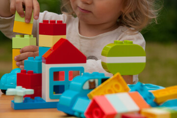 Colorful plastic toys and baby. Construction toys. Early development concept. Baby playing with colorful plastic toys. Baby playing in playground. Preschool concept 