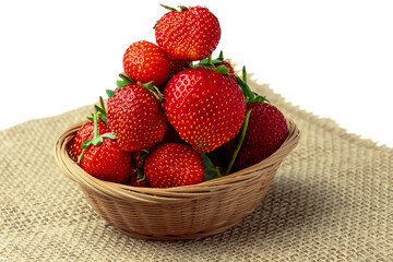 Strawberry. Sweet ripe fragrant strawberries in a basket on burlap isolated on a white background copy space.