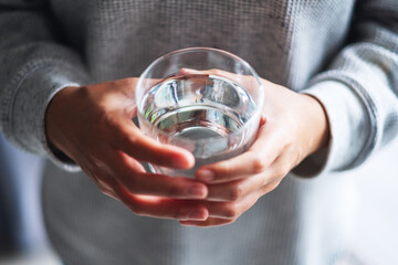 Closeup image of a woman holding a glass of pure water