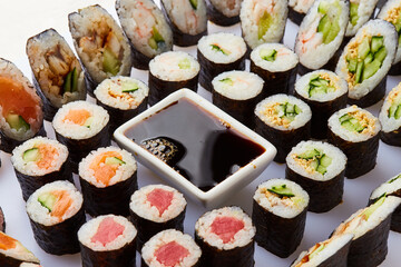 Various kinds of sushi roll set served on cutting board. Japanese food