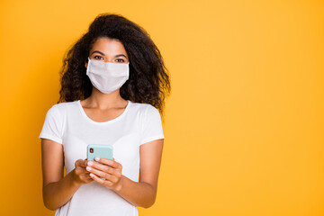 Portrait of her she attractive healthy wavy-haired girl wearing safety mask using gadget reading...