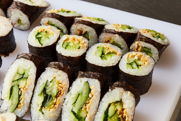 Various kinds of sushi roll set served on cutting board. Japanese food