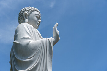 Detail of Buddha statue in a Buddhist temple and blue sky background in Danang, Vietnam. Closeup, copy space