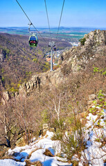 Obraz premium Cable car with gondola on a slope with snow in the Harz mountains. Saxony-Anhalt, Harz, Germany