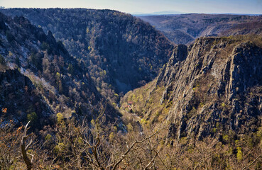 View from the mountains with trees to the gorge in the valley with old houses.