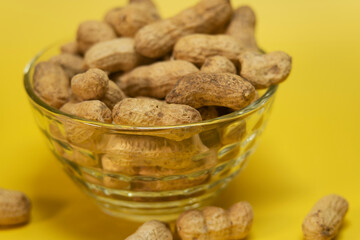 Peanuts in peel on a yellow background