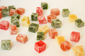 Multicolored Turkish delight are scattered on a light background. Oriental sweets, delicious moments are irreplaceable