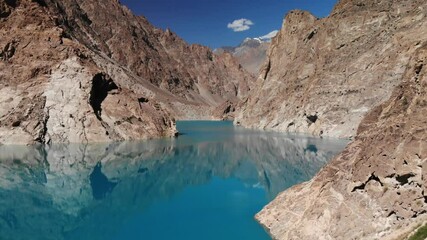 Breathtaking view of the turquoise Attabad lake, with the reflection of the mountains and peaks, aerial view of hills and snow peak in the background, beautiful Gilgit Baltistan area, Pakistan 