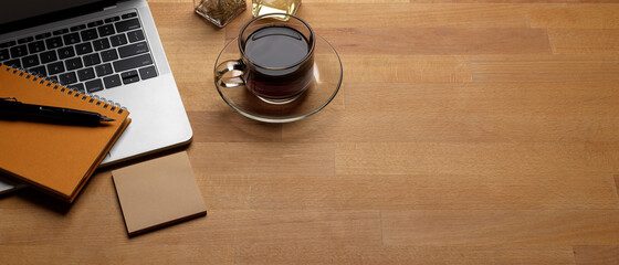 Trendy worktable with copy space, laptop, coffee cup and stationery on wooden desk