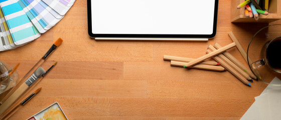 Artist workspace with mock-up tablet, painting tools, supplies and copy space