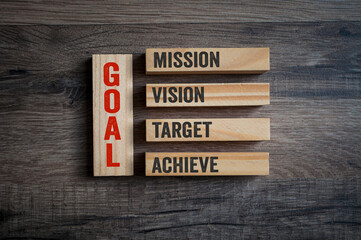 Wooden pieces with GOAL and mission, vision, target and achieve on wooden background