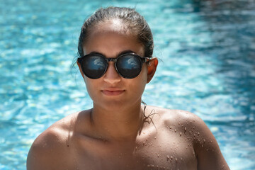 Fototapeta premium Sommerportrait junge Frau mit Sonnenbrille am Pool