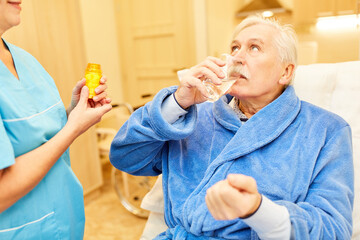Senior Mann nimmt Tabletten mit Wasser ein