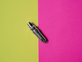dental implant model top view close up on pink and green background