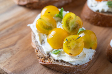 Close up of Italian bruschetta with cream cheese and yellow tomato cherry .Detail