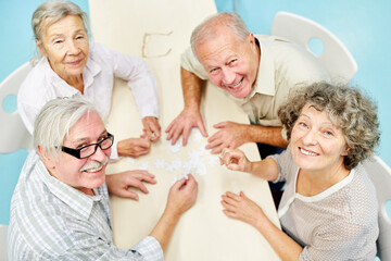 Rentner Gruppe hat Spaß beim Puzzle spielen