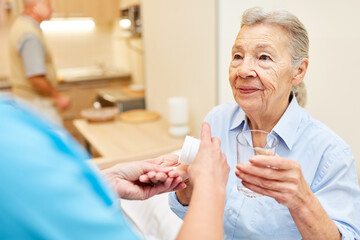Pflegekraft gibt Senior Frau Tabletten