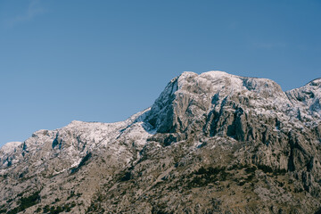 Fototapeta na wymiar Snow-capped mountain peaks in Boka Kotorska. Winter in Montenegro in Kotor Bay.