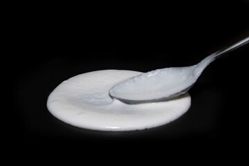 spreading dosa or idli batter on non stick tawa with spoon for making delicious dosa