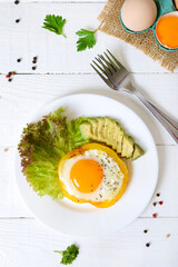 Fried eggs in a ring of yellow bell pepper. Healthy breakfast food. Proper nutrition. The top view