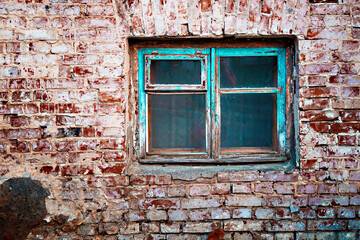 Old shabby wall facade of a brick building with wooden glass windows in turquoise color. The...