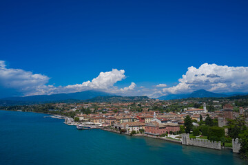 Fototapeta na wymiar Lazise, Lake Garda, Italy. Aerial view of the historic city of Lazise, in the background cumulus clouds on a blue sky