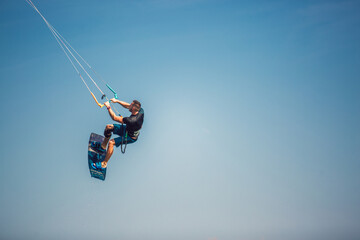 Professional kiter makes the difficult trick on a beautiful background. Kitesurfing Kiteboarding...