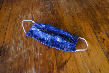 Home-made cloth mask on a wooden surface.  The masks were made for the covid-19/coronavirus...