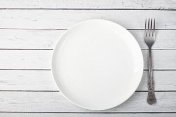 white plate with a fork on a wooden table
