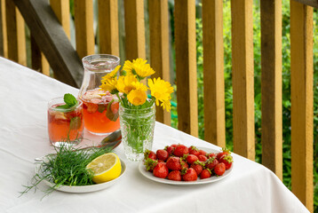 Table with summer snacks and strawberry lemonade outdoors