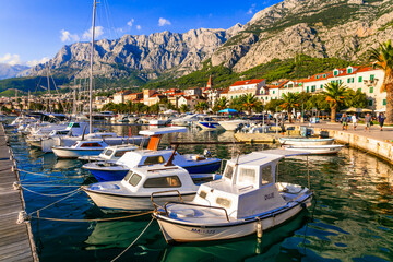 Fototapeta na wymiar Famous Adriatic coast - Makarska riviera in Dalmatia. Town Makarska, promenade and marine. 