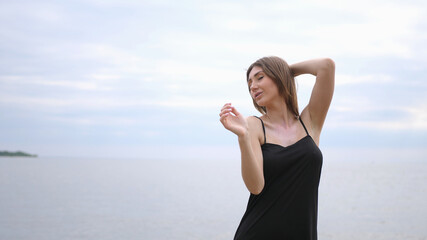 Fototapeta na wymiar Young beautiful woman dancing on the seashore