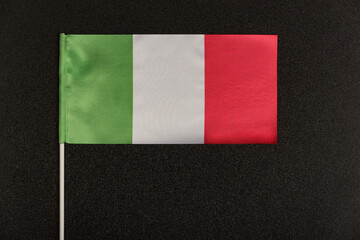 Tricolor Italian flag green white red on black background. Table flag of Italy