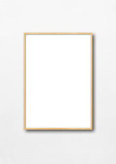 Obraz premium Wooden picture frame hanging on a white wall