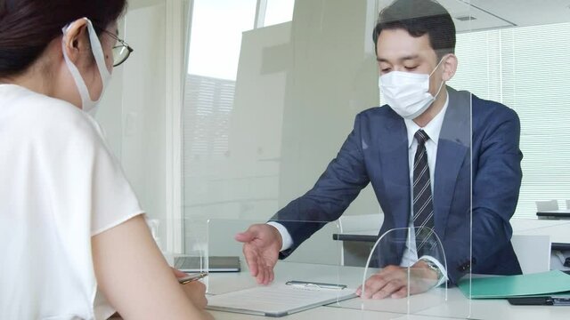 アクリルパーティション越しに話すビジネスマン　感染対策　120pスローモーション