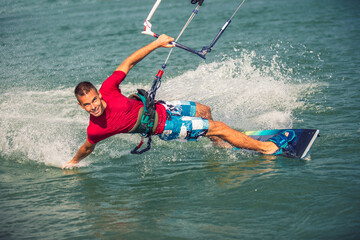 Professional kiter makes the difficult trick on a beautiful background. Kitesurfing Kiteboarding action photos man among waves quickly goes