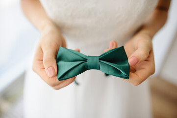 The bride shows the groom's bow tie.