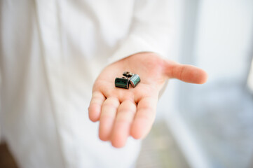 A man shows cufflinks on his hand. Close-up.