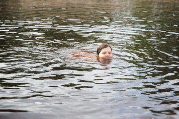 Girl child swims swimming in the river, child safety, the child drowns in water