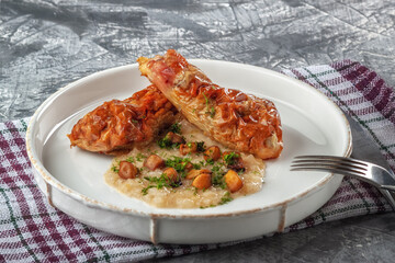 Chicken drumstick ballotin with onion sauce and mushrooms. Stuffed chicken legs